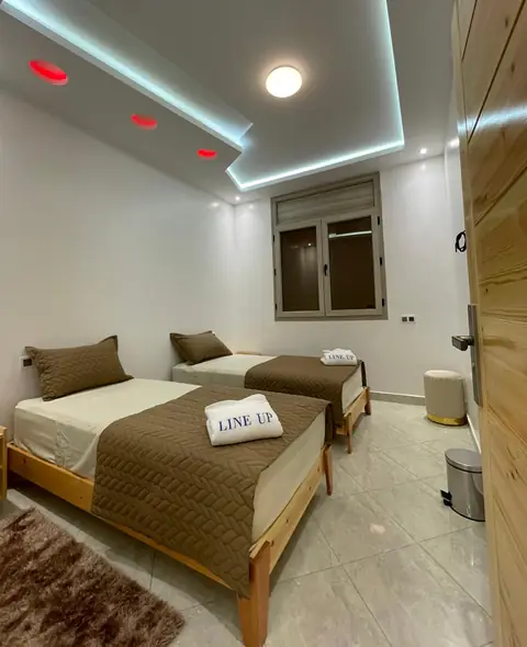 Sea-view twin room at Line Up: two single beds with brown covers and a folded LINE UP towel